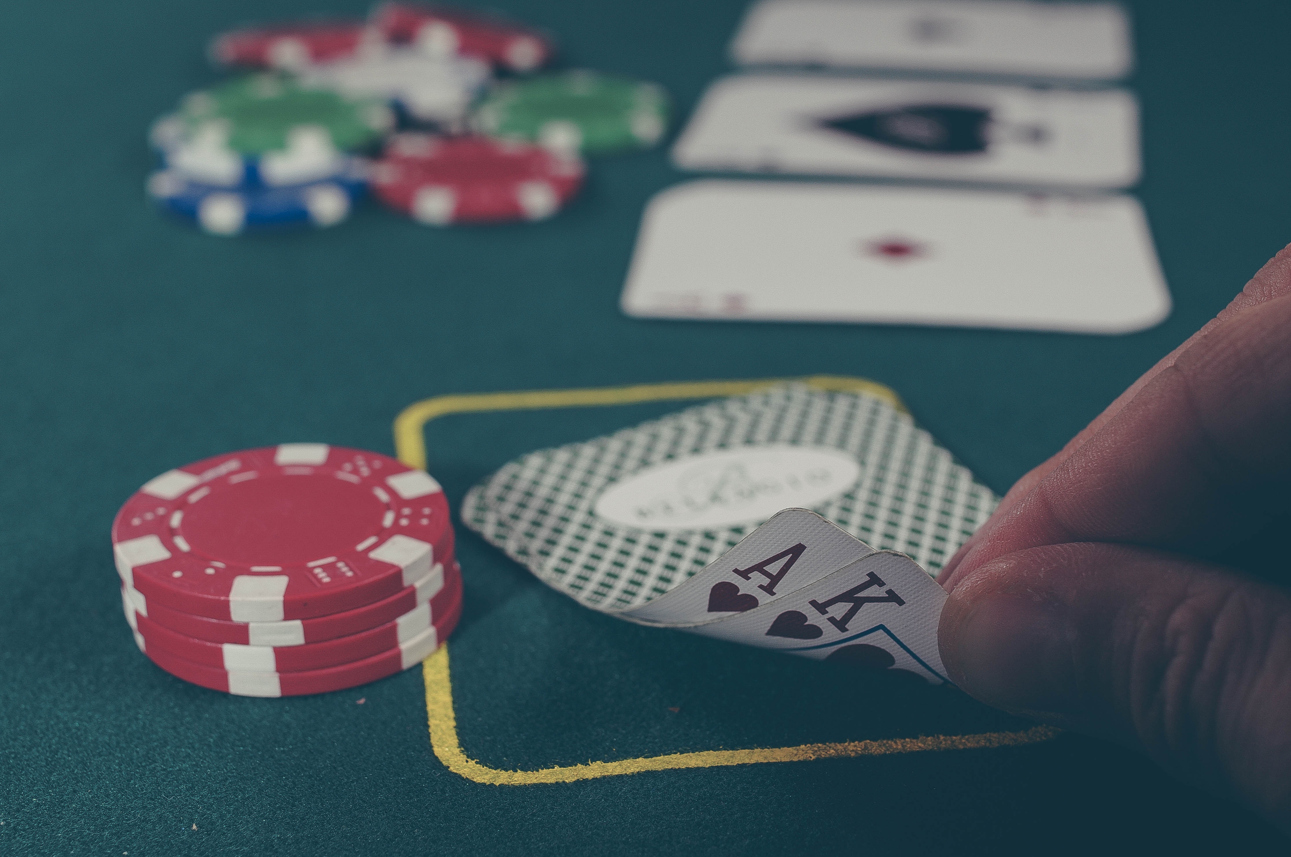 Pelaaja vilauttaa korttejansa ja pöydällä on pelipanoksia